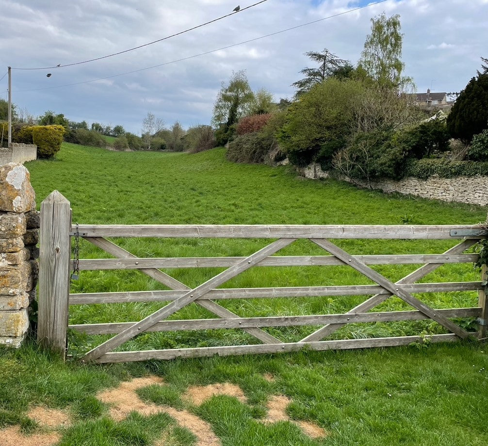 Image of a wooden gate into a meadow